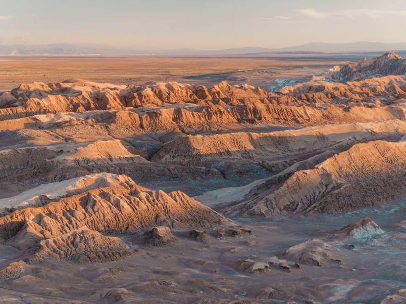 Sun setting over sharp red-hued ridges of the Atacama Desert