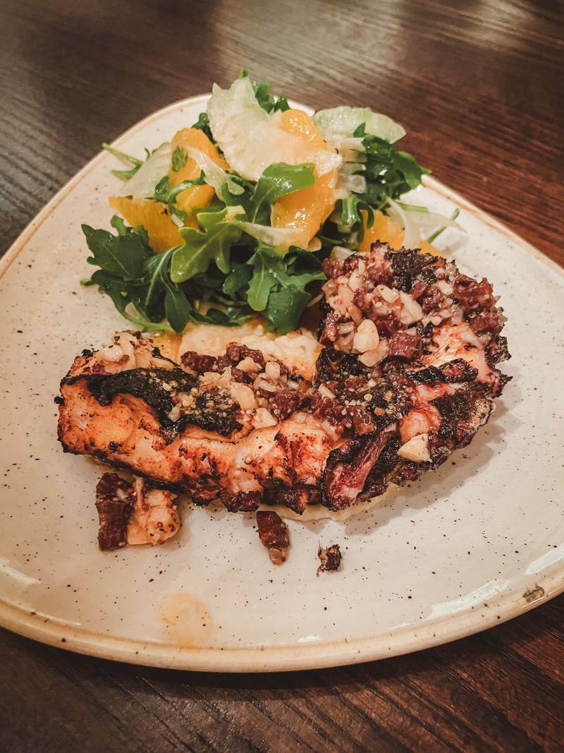 Plated grilled octopus dish with garnish at Buttermilk and Bourbon in Back Bay Neighborhood