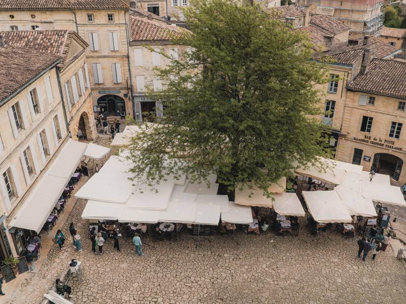 White awnings of booths in the Place du Marche of Saint-Emilion from panoramic overlook