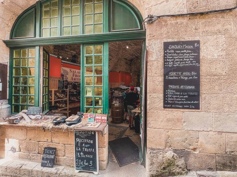 Green window panes on the stone wall of a sandwich maison in France