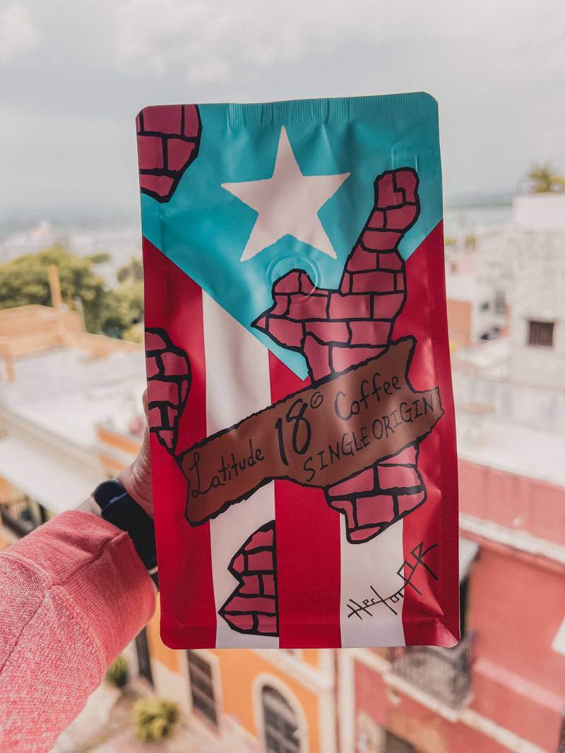 Puerto Rican flag design on package of local coffee held in front of city view