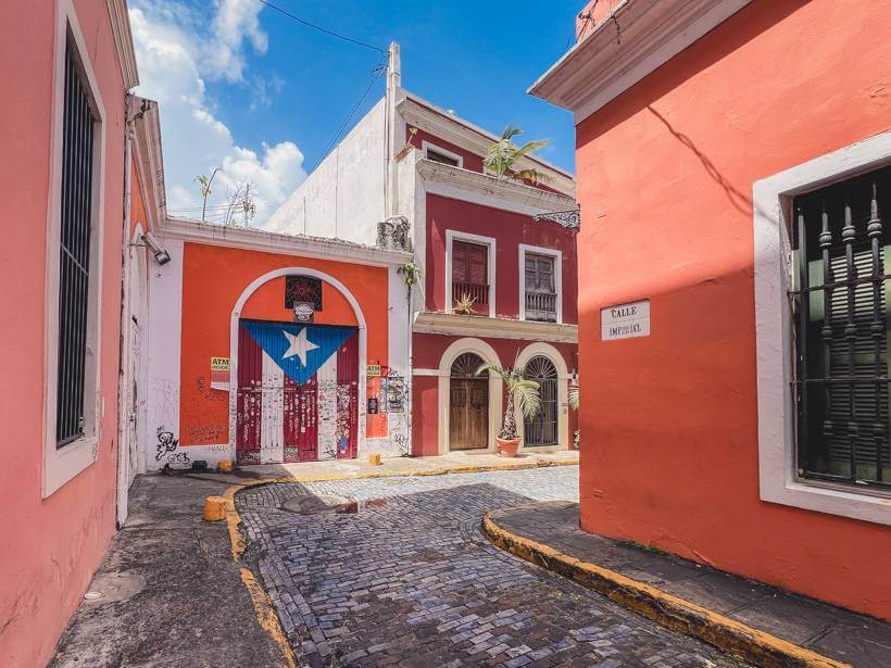 Street view of Puerto Rican flag painted on metal garage door on historic bright orange building